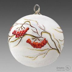 a glass ornament with red berries hanging from it's side on a gray background