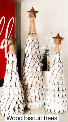 three white christmas trees with gold stars on them and one is made out of paper plates