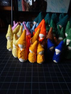 several different colored stuffed animals are lined up on a black table with a person in the background