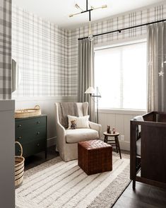 a baby's room with plaid walls and furniture