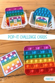 two plastic trays filled with different colored dots on top of a wooden table next to each