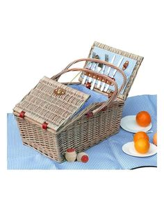 a wicker picnic basket with oranges on the table