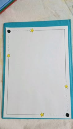 a blue and white paper with yellow stars on it next to some colored pencils