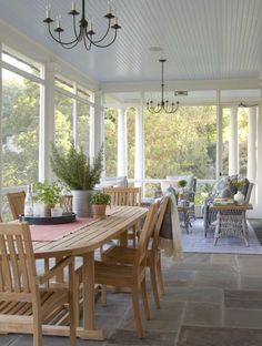 a dining room table with chairs and potted plants on the table in front of it