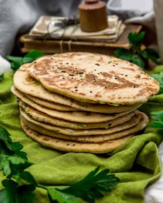 a stack of flatbreads sitting on top of a green cloth