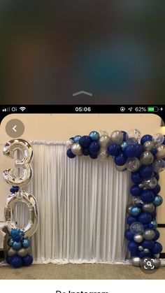 the balloon arch is decorated with blue and silver balloons