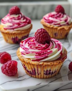 raspberry cupcakes with white frosting and fresh raspberries