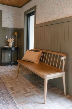 a wooden bench sitting in the middle of a room