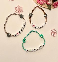 three personalized bracelets on a table with flowers