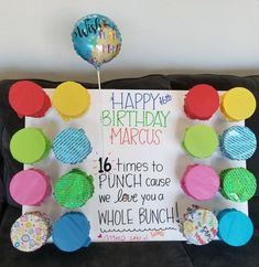 a birthday card with balloons and magnets attached to the back of a black couch