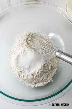 a whisk in a glass bowl with flour