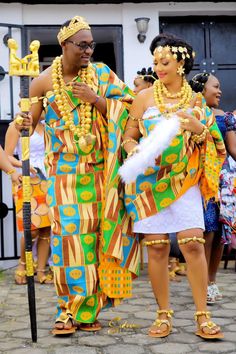 two people dressed in african clothing standing next to each other