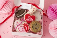 valentine's day cookies in a box with paper decorations