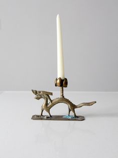 a candle that is sitting on top of a metal stand with two candles in it