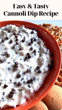 an orange bowl filled with whipped cream and chocolate chip cookies next to pretzels