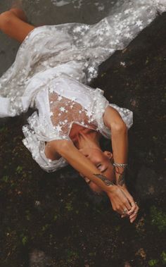 a woman in white dress laying on the ground