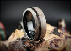 the wedding band is made out of wood and has a black ceramic inlay on it