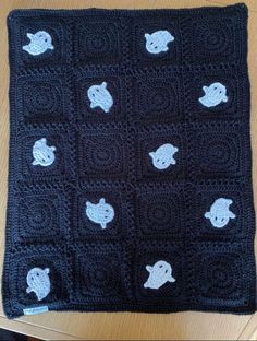 a black crocheted blanket with white elephants on it