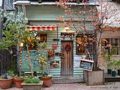 a store front with potted plants and signs