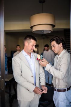 groomsman pinning boutonniere on grooms jacket. | Makayla McGarvey Photography • Arizona Elopement Photographer #elopementplanningtips #elopementideas #caboelopement #destinationwedding #destinationelopement Getting Ready Wedding