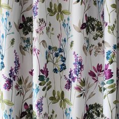 a close up view of a curtain with flowers and leaves printed on it, in front of a window