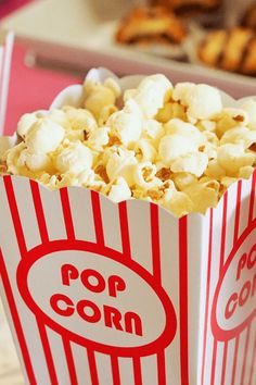 two red and white popcorn bags sitting on top of a table