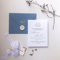 a blue and white wedding suite with a wax stamp on the front, ring in the middle