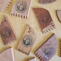 wooden spoons and spatulas are arranged on a wood table with carved logos