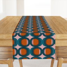 an orange and blue table runner sitting on top of a wooden table