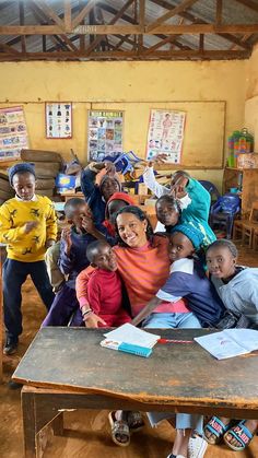 a group of children sitting at a table in a classroom