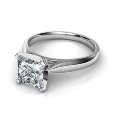 a white gold ring with a princess cut diamond in the center, on a white background