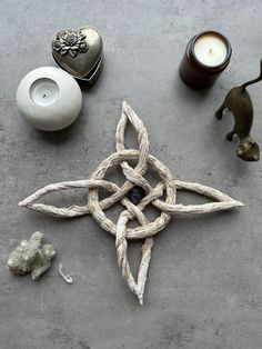 a star made out of rope next to two candles and other items on the ground