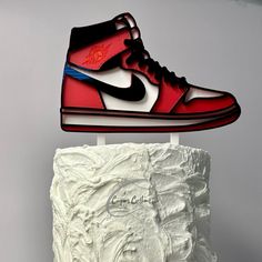 a red and white shoe on top of a cake