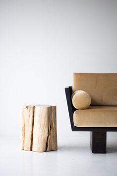 a couch and table made out of tree stumps in front of a white wall