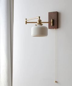 a wall light that is attached to the side of a wall next to a window