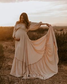 a pregnant woman wearing a dress in the desert