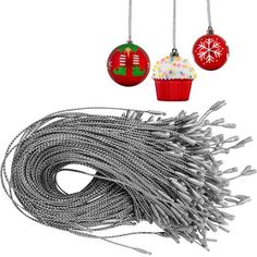 three christmas ornaments hanging from silver wire and two cupcakes with frosting on them