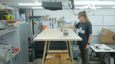 a woman standing at a table in a garage