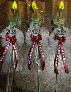 three flowers with ribbons tied to them in plastic bags