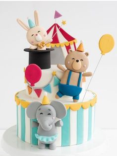 there is a cake that has animals on it and balloons in the air next to it