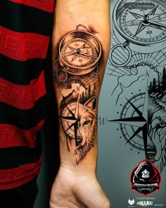 a person with a tattoo on their arm holding a compass and a wolf's head