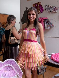 a woman standing in front of a cake with pink icing on it's sides