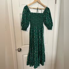 a green dress hanging on a white door