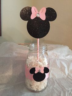 a mason jar filled with rice and minnie mouse ears