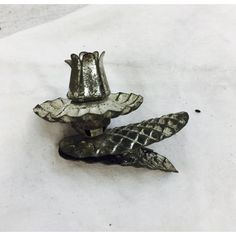 two metal objects sitting on top of a white table next to each other and one is shaped like a snake