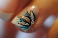 a woman's hand with some blue and white nail art designs on her nails