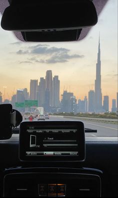 the view from inside a car looking out at a cityscape with skyscrapers in the distance