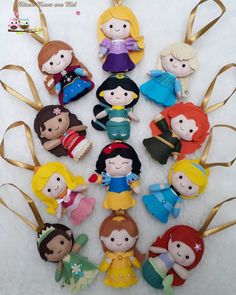 a bunch of little princess dolls sitting on top of a white surface with gold ribbon