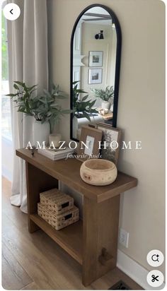 a mirror sitting on top of a wooden table in front of a wall mounted shelf