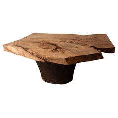 a piece of wood that is sitting on top of a wooden table with a black base